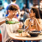 Asian couple enjoying street food in Hong Kong