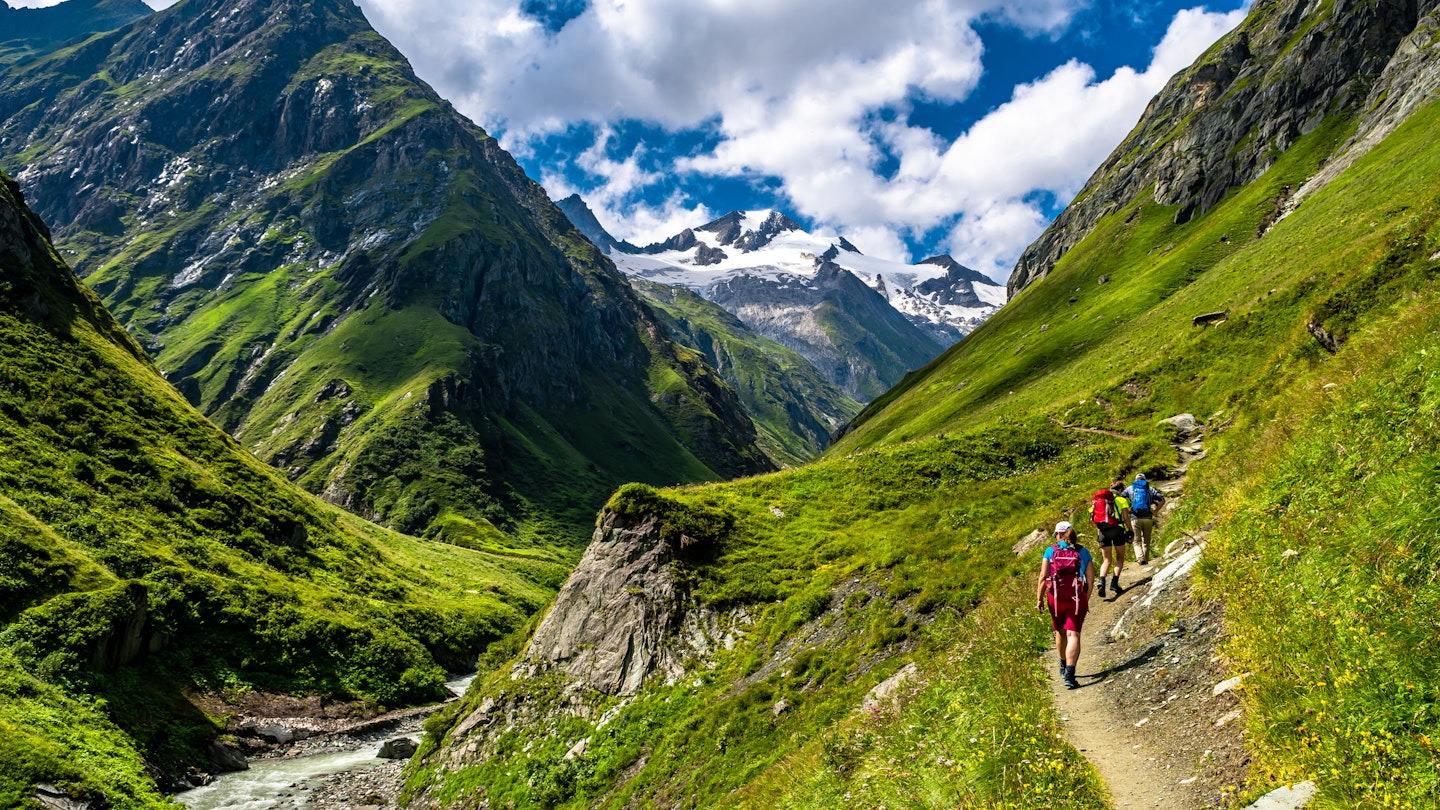 A group hiking in the valley Of Umbalfaelle On Grossvenediger With View To Mountain Roetspitze In Nationalpark Hohe Tauern In Tirol In Austria