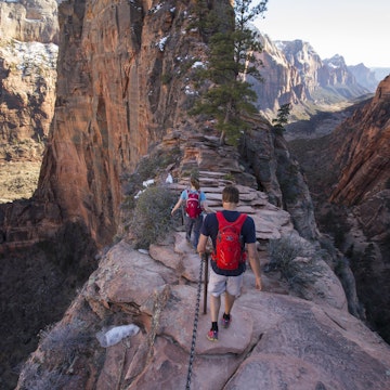 A man and woman hiking Angels Landing in Zion national Park.