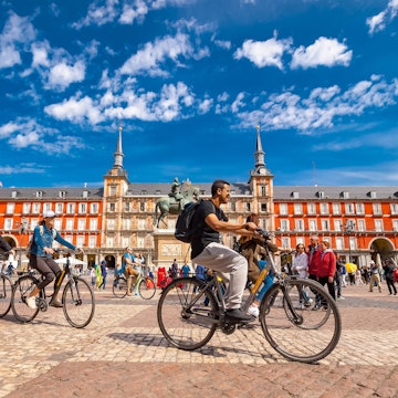 Spain, Madrid..A view of  La Plaza Mayor square in Madrid where there were a group of tourists riding bicycles. The Plaza Mayor square is one of the most famous squares in the town and located in the city center. People walk and cycle through the streets.The Plaza Mayor (Main Square) was built during Philip III's reign (1598–1621).