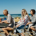 855782772
Three friends laughing on a tandem bicycle on a boardwalk in Cape Town