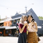 Two slightly dorky hipsters enjoying a day walk in the sunny Surry Hills, Sydney, Australia. The girls are happy to spend some time together eating ice cream and drinking cold drinks.