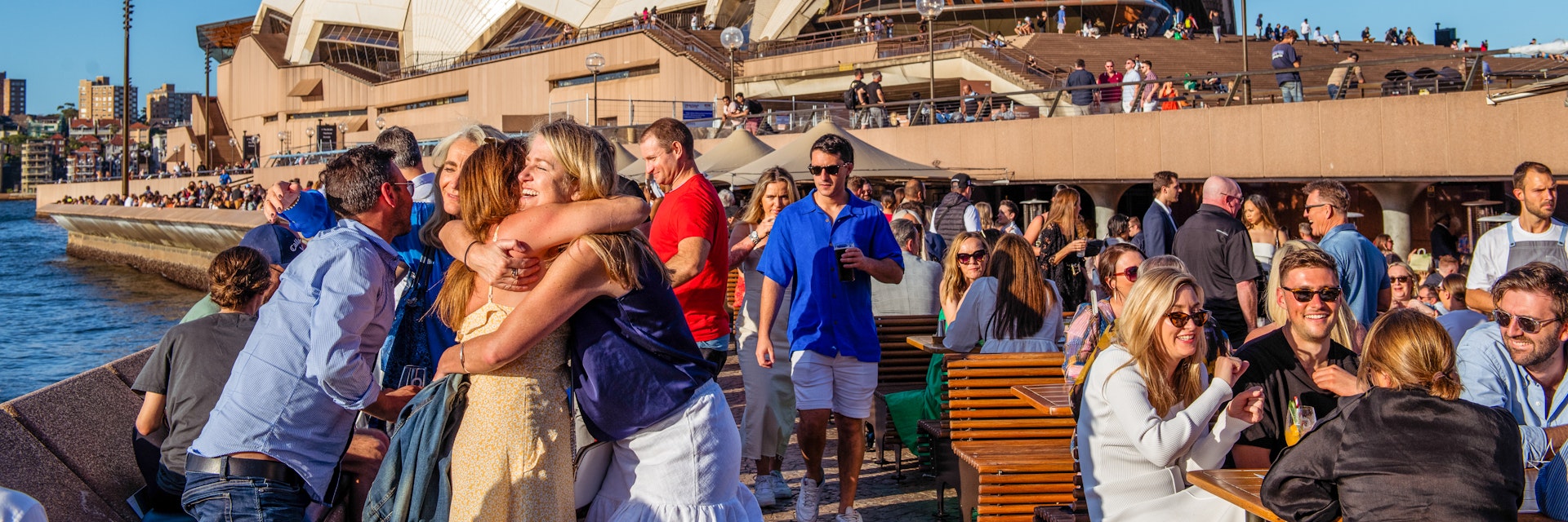 Friends hug in front of the Sydney Opera House © Isabella Moore/Lonely Planet