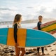 Two female friends with surfboards.